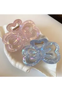 Detail of pink and blue hollow butterfly hair claws with pearlescent finish on ceramic tray