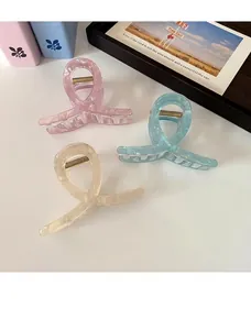 Detailed view of translucent marble textured hair claws in pastel pink and blue