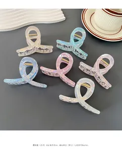 Detail view showing a set of six pearlescent claw clips with elegant twist design