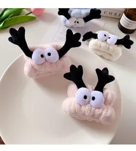 Close-up of soft coral fleece headbands with cute eyes and antlers for face washing
