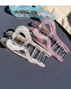 Detailed view of iridescent heart-shaped hair claws in pastel blue, pink, and white tones