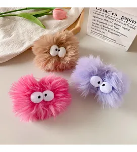 Close-up of plush monster wristbands with big eyes in rose red, purple and brown colors