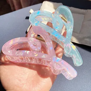 Iridescent heart-shaped hair claw clips in translucent pink and blue for elegant styling