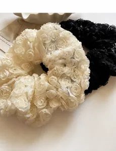 Detailed macro view of lace hair scrunchies with floral texture and branding labels