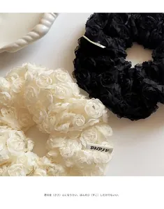 Detail of 3D rose lace scrunchies in black and beige with delicate floral texture