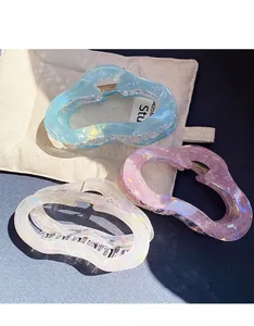 Detailed set of three large iridescent claw clips in pastel blue, pink, and pearl white