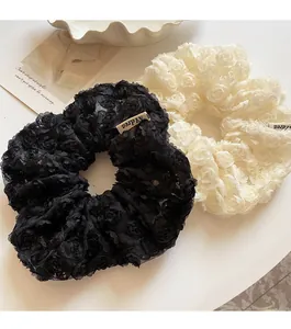 Detail of 3D layered lace rose hair scrunchies in elegant black and off-white mesh