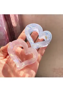 Close-up of heart-shaped iridescent claw clips in pink and blue with laser-like shine