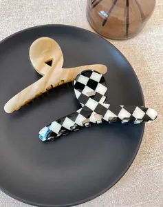 Detail of marble and checkerboard hair claws with golden Barrette La France lettering