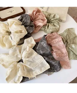 Detailed embroidery on colorful lace scrunchies with delicate floral edging textures