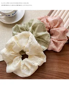 Detail of organza embroidery scrunchies in cream, bean green, and dusty pink shades