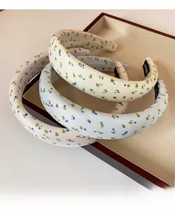 Detail of floral sponge headbands in three colors on a tray with handmade label