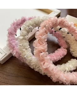 Gros plan de serre-têtes en mesh plissé avec dents antidérapantes en rose et beige