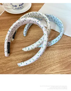 Detail of handmade floral headbands in cream and light blue with delicate fabric texture
