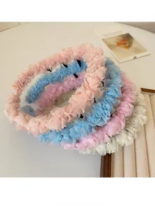 Gros plan de bandeaux plissés en maille pour filles en rose poudré, bleu ciel et blanc crème