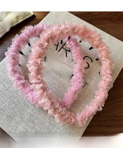 Vue détaillée de serre-têtes en maille rose plissée avec une texture de tissu élégante