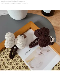 Detail of checkered seersucker bow hair clips with Lucky embroidery on wood frame