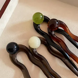 U-shaped acetate hair pins with ball tops in green, amber, cream, and brown colors