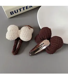 Detailed shot of bow hair clips with textured fabric and soft knit-wrapped clips