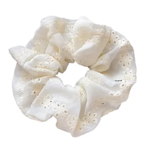 Elegant beige lace scrunchie with intricate floral embroidery and breathable fabric texture