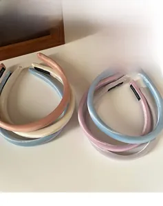 Détail du serre-tête en satin rembourré montrant l'étiquette faite main et la texture douce