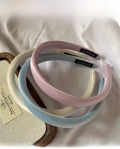 Détail de serre-têtes en satin rembourré rose, bleu et blanc avec étiquettes faites main