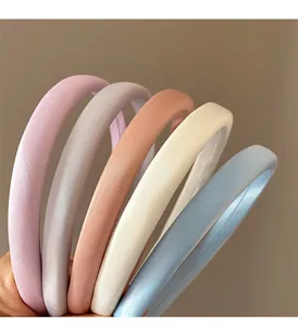 Vue détaillée de serre-têtes en satin rembourré déclinés en cinq couleurs pastel douces