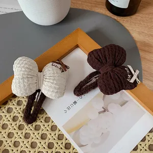 Chic cream and coffee puffy bow hair clips with lucky embroidery on a wooden frame