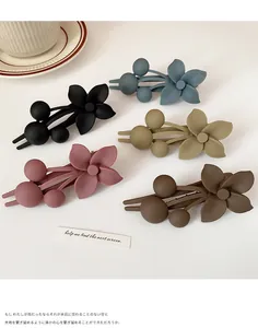 Detail of matte flower hair clips in Morandi colors including olive, navy and dusty pink