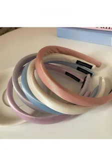 Détail du serre-tête en satin fait main montrant la texture soie et couleurs macaron