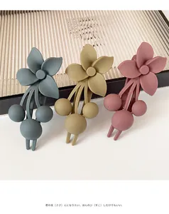 Detailed macro of Morandi flower hair clips with a matte finish in blue, yellow and pink