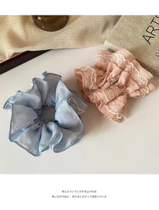 Dettaglio di elastici per capelli blu e rosa con ricami in pizzo floreale bianco fine
