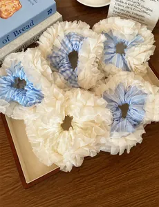 Detail of blue striped and white organza scrunchies in a wooden tray with a cozy aesthetic