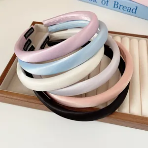 Lot de six serre-têtes rembourrés en satin aux tons pastels sur plateau de bijoux