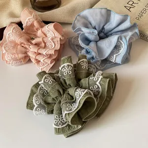 Tre elastici scrunchie rosa, blu e oliva con ricami floreali in pizzo eleganti