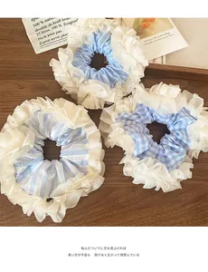 Detail of three blue and white layered lace scrunchies on a wooden surface in a cozy setting