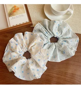 Détail de chouchous blancs à pois fleuris et motifs de cerises à carreaux bleus