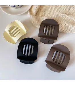 Close-up of four matte square hair claws in neutral tones with hollowed-out design