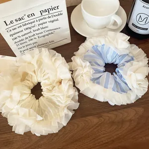 Oversized blue and white tiered lace hair scrunchies on a wooden table setup