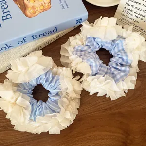 Light blue plaid and striped oversized lace scrunchies on a wooden background