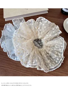 Detail of oversized lace embroidery hair scrunchie with floral pattern on wooden table