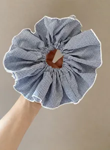 Κοντινό πλάνο μεγάλου scrunchie με μπλε και λευκό καρό σχέδιο και λευκές ραμμένες άκρες