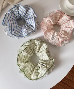 Close-up of pastel plaid scrunchies with white lace edges in blue pink and green