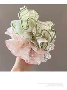 Detail of oversized mint plaid scrunchie with lace trim and bowknot design