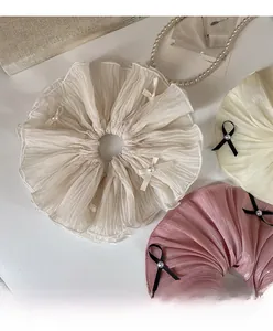 Detail of elegant organza hair scrunchies with pearls and mini bows in soft pastel tones