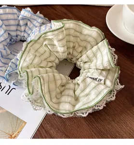Detail of mint green and blue plaid scrunchies with white lace edges on a wooden table
