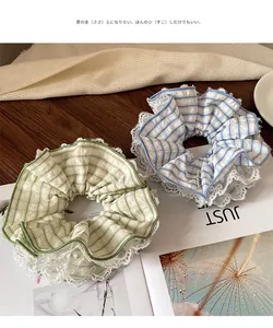 Detail of mint green and blue plaid scrunchies with white lace edges on magazine background