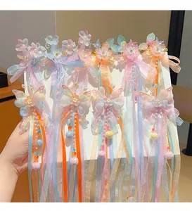 Close-up of pastel butterfly hair clips with flowing ribbons and beaded tassels