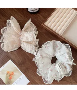 Primer plano de coletero floral y clip de lazo de encaje con detalles bordados