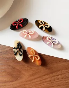 Detail view of a 6-piece acetate bow hair clip set featuring sparkling crystal accents